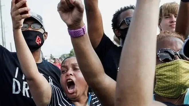 People shout and hold their phones during protests over George Floyd's death