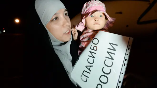 Спасенные из Сирии женщины выходили из самолета с табличками, на которых были написаны слова благодарности России и Кадырову