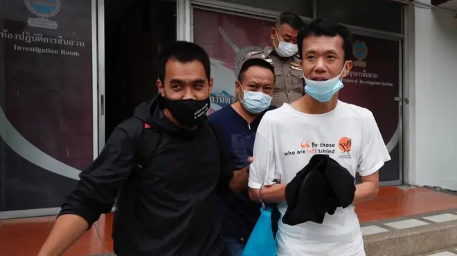 เจ้าหน้าที่นำนายเอกชัย หงส์กังวาน ผู้ต้องหาในความผิดตามมาตรา 110 ว่าด้วยการประทุษร้ายต่อพระราชินี ถูกนำตัวมาทำบันทึกการจับกุมที่ สน.ลาดพร้าว