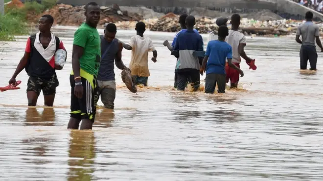 People dey try navigate road after heavy rain for Abidjan , Cote Ivoire for May dis year.