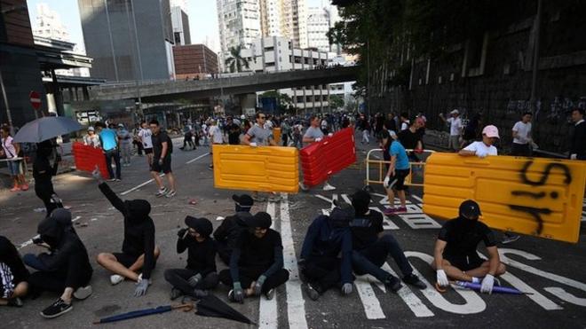 11月16日，有香港市民在街头清除抗议人士摆放的障碍物。