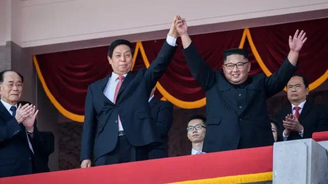 朝鮮領導人金正恩在國慶70週年閲兵式上與習近平特別代表栗戰書攜手歡呼。