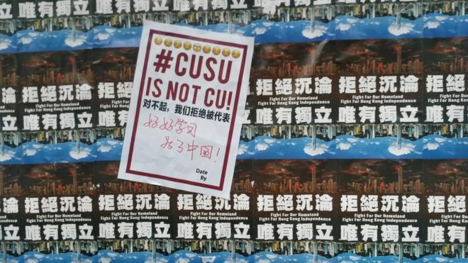 民主墙上一张写有"CUSU IS NOT CU"（中文大学学生会不等同中文大学）的海报遮盖着一些写有"拒绝沉沦　唯有独立"的海报