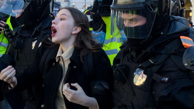 Полицейские задерживают женщину во время антивоенного протеста в Санкт-Петербурге 13 марта