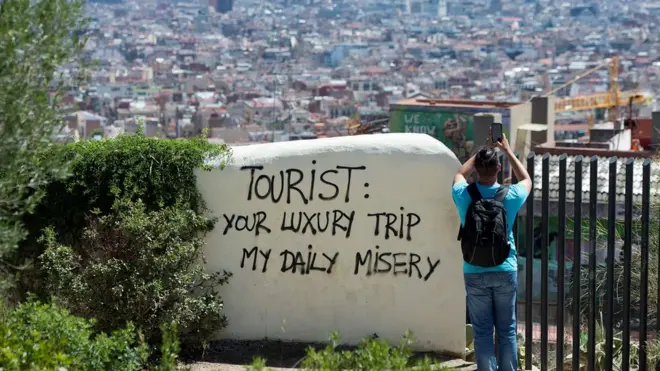 Barcelonada bir duvarda "Turist: Sizin için lüks seyahat, bizim için eziyet" yazıyor.
