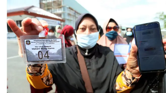 Peziarah menunjukkan aplikasi PeduliLindungi serta tanda izin masuk di depan Pos Pemeriksaan Kawasan Wisata Makam Presiden Soekarno di Kota Blitar, Jawa Timur, Selasa (21/9/2021).