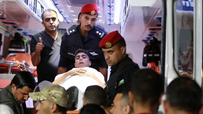 عناصر من قوات الأمن الأردني خلال استقبال طفل فلسطيني مريض أجلي من قطاع غزة لتلقي العلاج في المملكة