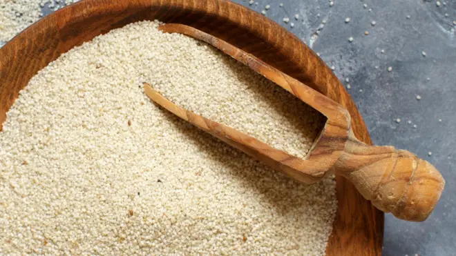 Graines de fonio crues non cuites avec un fond gris de cuillère