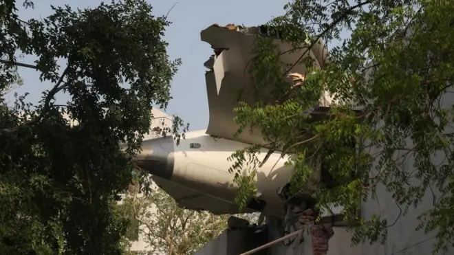 建物に突入したインド航空ボーイング787ドリームライナーの尾翼（12日、インド・アーメダバード）