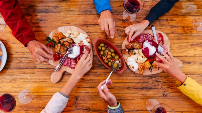 مائدة وأيدٍ تتناول الطعام 