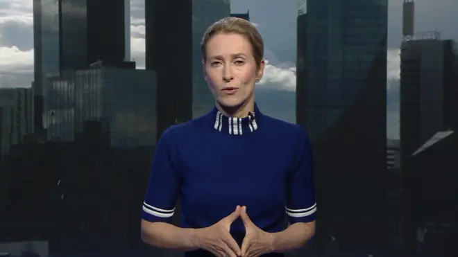 Umugore w'umu blonde mu mpuzu y'ubururu inigirije mw'izosi ariko aravuga araba camera micro bayifatishije kw'ikoro. Ariko aravuga yageranije ibiganza