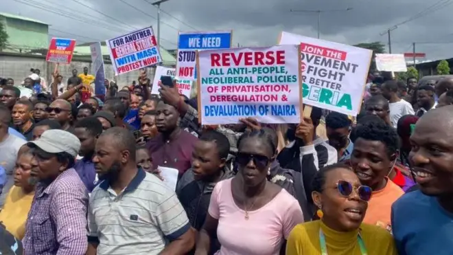 Protesters carry different placards to protest end to band governance for August