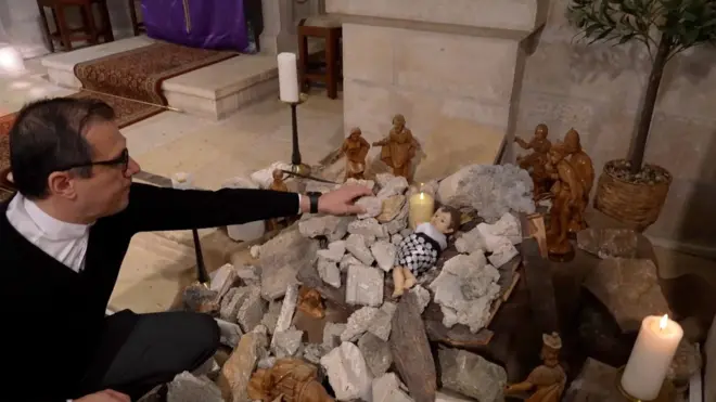 القس منذر اسحق مع مجسم يسوع المسيح في بيت لحم
