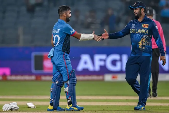 Afghanistan's captain Hashmatullah Shahidi greets Sri Lanka's Dimuth Karunaratne (R) at the end of the 2023 ICC Men's Cricket World Cup one-day international (ODI) match between Afghanistan and Sri Lanka at the Maharashtra Cricket Association Stadium in Pune on October 30, 2023