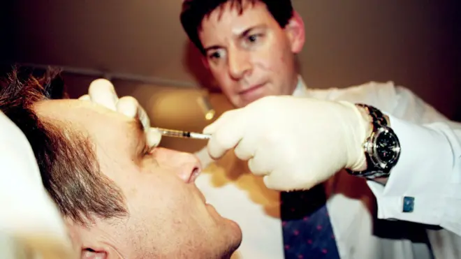 طبيب يحقن رجلاً بالبوتوكس