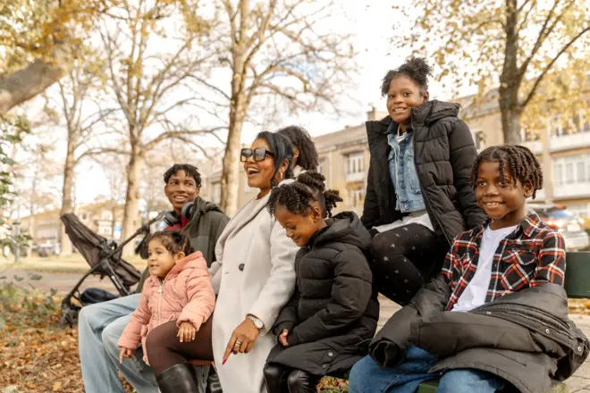 Belle mère noire avec sa famille de six enfants lors d’une promenade d’automne dans le parc