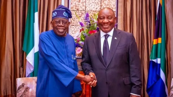 Nigerian President Bola Ahmed Tinubu (L) shake hands wit South African President Cyril Ramaphosa (R)