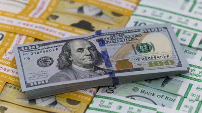 한국의 오만원권과 만원권 지폐 위로 미국의 백달러 지폐 뭉치가 올려져 있다