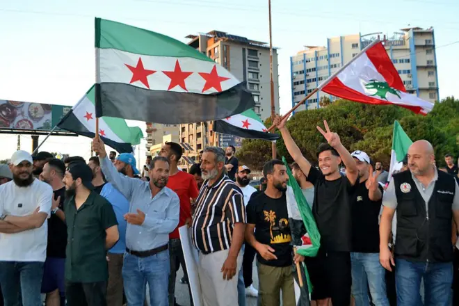 مجموعة من المواطنين اللبنانيين يرفعون الأعلام السورية واللبنانية ترحيبا بوزير الخارجية السوري أسعد الشيباني خلال زيارته للبنان أول يوليو الماضي
