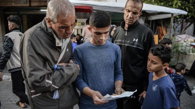 مواطنين في غزة يشاهدون المناشير