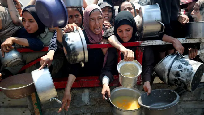 صورة لفتيات فلسطينيات يتجمهرن أمام أحد المطابخ الخيرية للحصول على وجبة طعام في مدينة غزة.