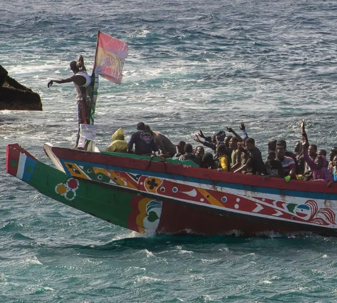 Un groupe de migrants célèbre son sauvetage en mer lors de la traversée entre l'Afrique et l'Europe, quelques minutes avant d'entrer dans le port de La Restinga, aux îles Canaries. 