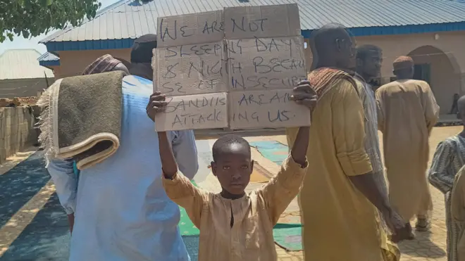 One boy hold placard to protest against, wetin one teacher, local councilor and parents tok, di kidnapping of hundreds school pupils by gunmen afta di Friday prayer for Kaduna, Nigeria March 8, 2024. 