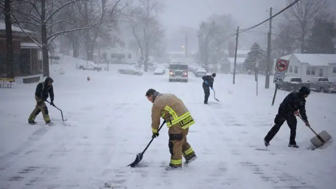 إطفائيون يحاولون إزالة الجليد من الطرقات في كنتاكي