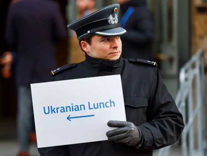 Полицейский в Мюнхене держит знак Ukrainian Lunch
