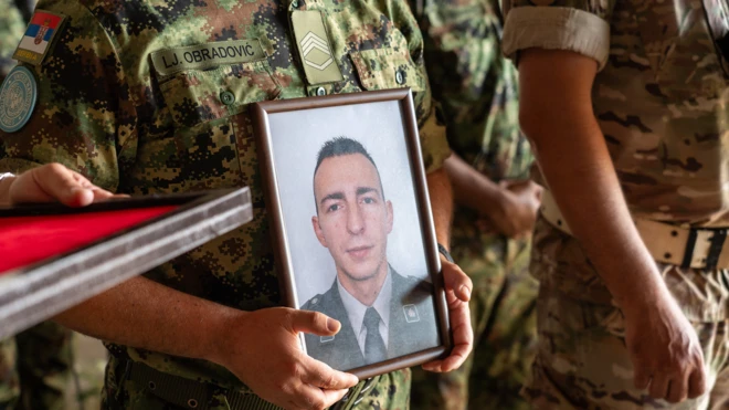 Мушкарац држи фотографију погинулог војника