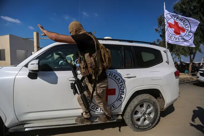 نیروهای حماس در همراهی با خودروهای صلیب سرخ هنگام انتقال گروگانها