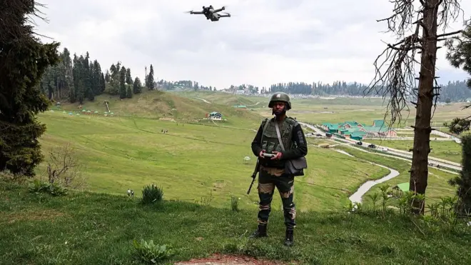 An Indian soldier of the BSF keeps vigil while using a drone in Gulmarg, Jammu and Kashmir, India, on May 3, 2025. The Jammu and Kashmir government closes 50 tourist spots citing security after the Pahalgam terror attack. (Photo by Nasir Kachroo/NurPhoto via Getty Images