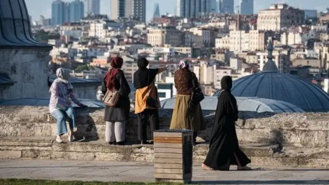 başörtülü 5 kadın istanbul silüetine bakıyor, arkaları dönük