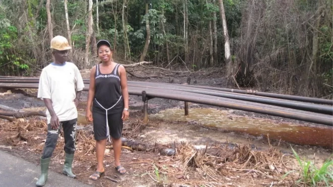 Nwaichi posant à proximité d'un sol pollué