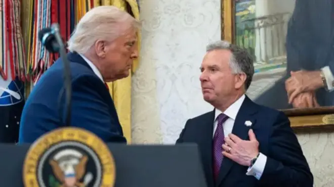 يظهر وجه ويتكوف الذي يرتدي بدلة رسمية كحلية اللون وقميصا أبيض وربطة عنق بنفسجية مقابل ترامب الذي يظهر وجهه من الجانب ويرتدي بدلة رسمية كحلية وقميصا أبيض ويبدو أنهما يتصافحان.