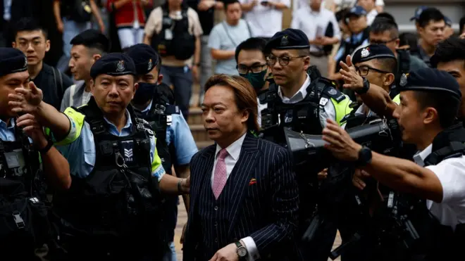 Lawrence Lau Wai-chung is escorted by police outside the West Kowloon Magistrates' Courts building after being acquitted of charges under the national security law, in Hong Kong, China, May 30, 2024. REUTERS/Tyrone Siu