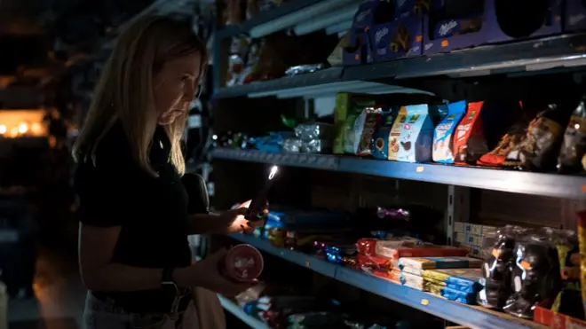 어두운 가게 안에서 물건을 구매하는 사람들