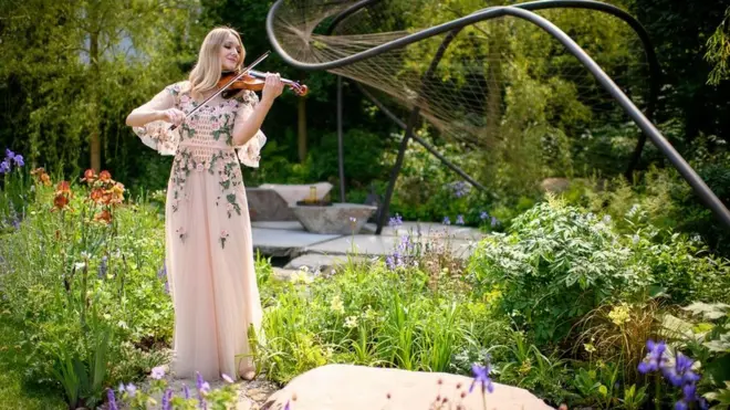 Сүрөттө скрипач Салли Поттертон Веджвуд бакчасында. Бул XVIII кылымдагы бакчаны символдоштурган.