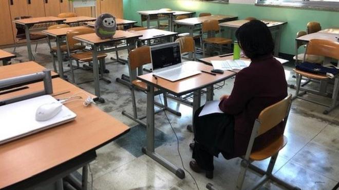 韩国的一名教师在学校里通过手提电脑与学生连线沟通。