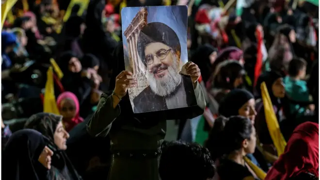 أنصار لحزب الله يحملون صورة نصر الله