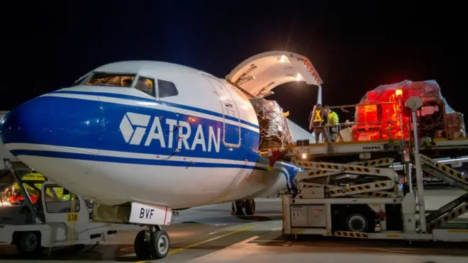 Personal cargando un Boeing-737 operado por la aerolínea de carga Volga-Dnepr en el Aeropuerto Internacional de Vnúkovo en Moscú.