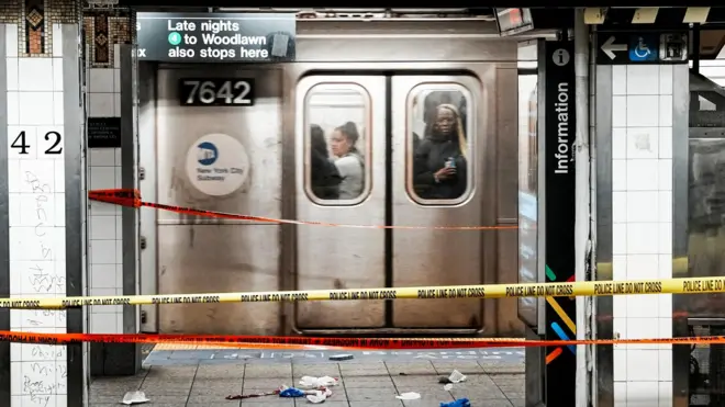 Пассажиры поезда проезжают мимо места нападения, 11 апреля 2026 года в метро на станции «Гранд Сентрал» в Нью-Йорке (США).