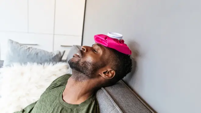 Man using an ice pack for a fever