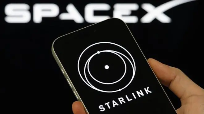 смартфон із заставкою Starlink на тлі лого SpaceX