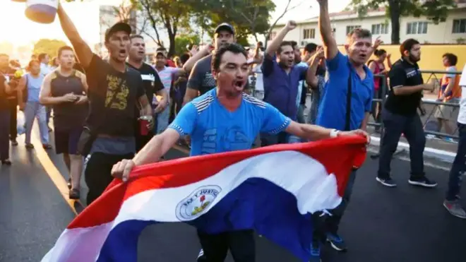 Un hombre con una bandera de Paraguay en una protesta de agricultores.