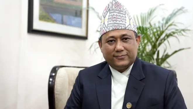 परराष्ट्रमन्त्री शिशिर खनाल। उनले नीलो रङ्गको कोट र सेतो दौरासुरुवाल र ढाका टोपी लगाएका छन्