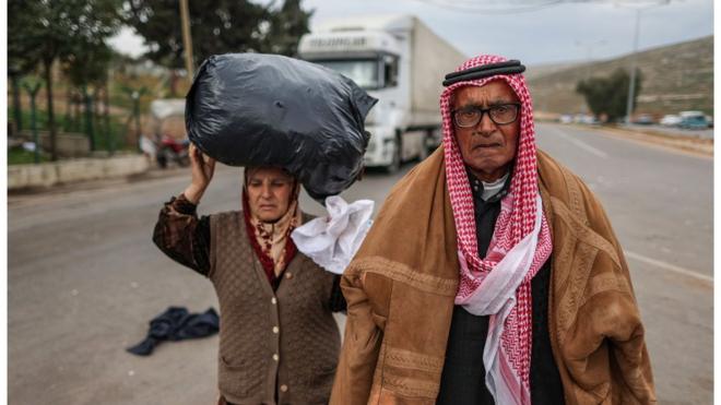 لاجئان سوريان ينتظران العبور إلى سوريا عند بوابة سيلفيغوزو الحدودية مع تركيا