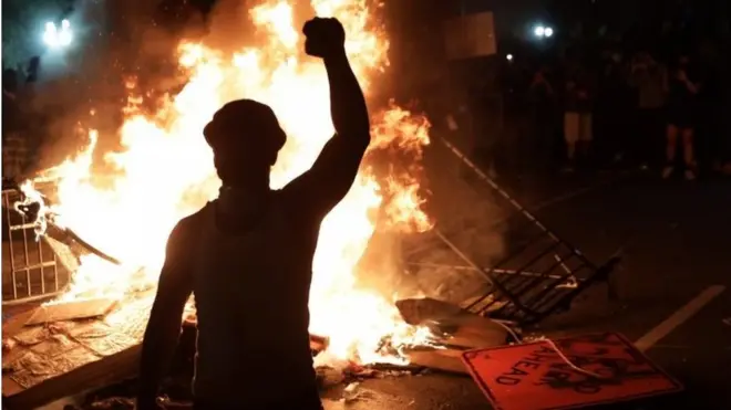A protesters stands by a fire near the White House in Washington DC. Photo: 31 May 2020
