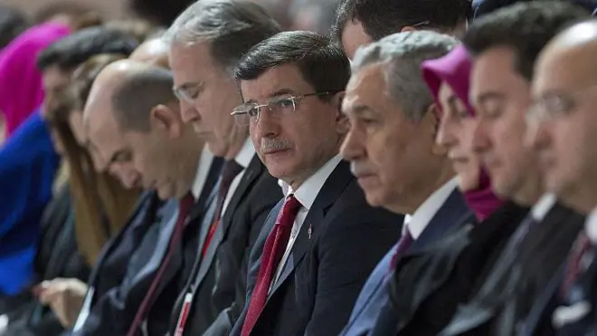 Arınç ve Davutoğlu yan yana oturuyor. Yanlarında çok sayıda siyasetçi daha var. Herkes ileri bakıyor, fotoğraf yandan çekilmiş