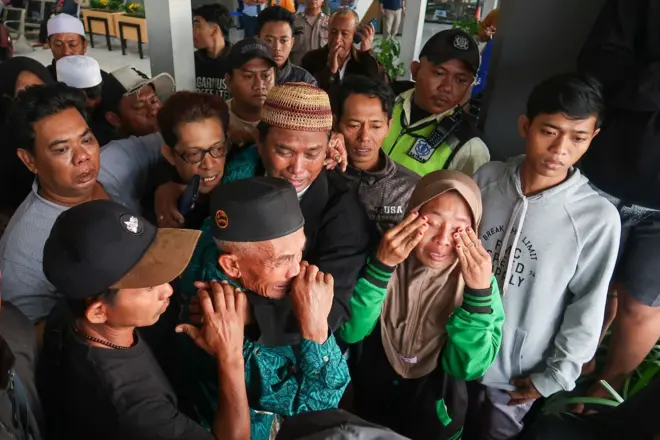 Sejumlah orang sedang menangis saat menanti kabar pencarian kapal yang tenggelam di Selat Bali